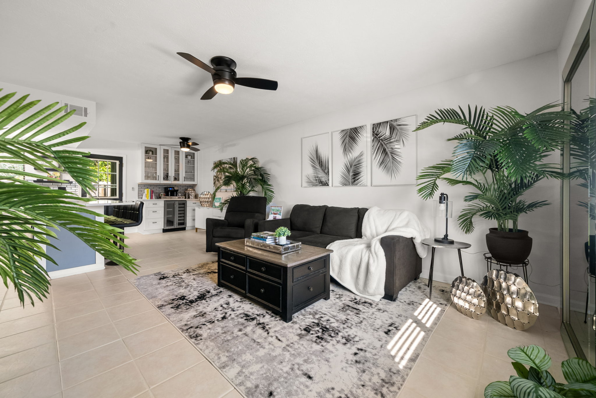 Bright open living room of the short-term rental with seating, rug and adjoining kitchen